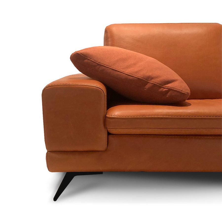 Le coin d'un canapé Long Island en cuir cognac, coussin d'appui et pied de métal noir