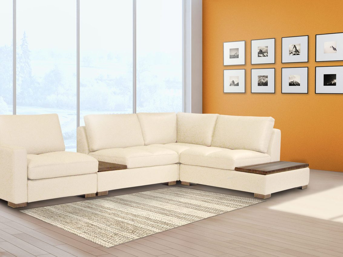Un sectionnel William crème avec table d'appoint intégrée, devant un mur orange et une grande fenêtre sur la neige